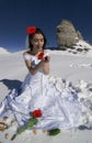 Bride adorned with crimson flowers.