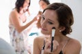 Bride applying her makeup doing her wedding preparation