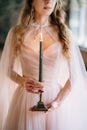 Bride in a beautiful dress with a burning candle in her hands Royalty Free Stock Photo