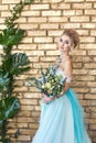 Bride in a beautiful turquoise dress in anticipation of wedding. Blonde in lace dress sea green with a bouquet . Happy bride Royalty Free Stock Photo