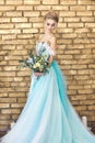 Bride in a beautiful turquoise dress in anticipation of wedding. Blonde in lace dress sea green with a bouquet . Happy bride Royalty Free Stock Photo