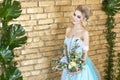 Bride in a beautiful turquoise dress in anticipation of wedding. Blonde in lace dress sea green with a bouquet . Happy bride Royalty Free Stock Photo