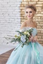 Bride in a beautiful turquoise dress in anticipation of wedding. Blonde in lace dress sea green with a bouquet . Happy bride Royalty Free Stock Photo