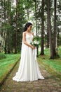 Bride in a beautiful white dress and a bouquet of flowers in her hands is waiting for the wedding ceremony. Beautiful woman with a Royalty Free Stock Photo