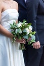 A bride in a beautiful white wedding dress holding a bridal bouquet standing next to the groom Royalty Free Stock Photo