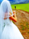 Bride with a beer bottle and a groom on bicycle on the background - wedding concept.