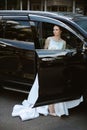 bride with a black car Royalty Free Stock Photo