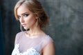 Bride blonde woman in a modern color wedding dress with elegant hair style and make up. Fashion beauty portrait