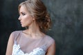 Bride blonde woman in a modern color wedding dress with elegant hair style and make up. Fashion beauty portrait