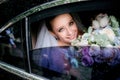 Bride with blue eyes holds tender wedding bouquet sitting in the car Royalty Free Stock Photo