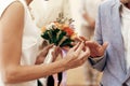 Bride with bouquet and groom exchanging wedding rings at wedding Royalty Free Stock Photo