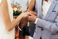 Bride with bouquet and groom exchanging wedding rings at wedding Royalty Free Stock Photo