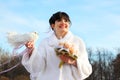 Bride with bouquet holds white dove Royalty Free Stock Photo