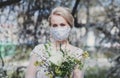 Bride with a bouquet in a protective mask