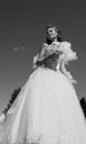 The bride with a bouquet and the sky.