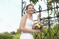 Bride With Bouquet Standing By Gate Royalty Free Stock Photo