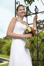 Bride With Bouquet Standing By Gate Royalty Free Stock Photo