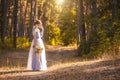 Bride with a bouquet is walking the green park Royalty Free Stock Photo