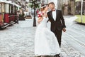 Bride and bridegroom walking across cobbled street Royalty Free Stock Photo