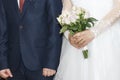 Bride and bridegroom on wedding ceremony. Bouquet of roses in hands of lady. Beautiful wedding dress and elegant costume