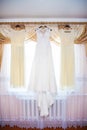 bride and bridesmaids dresses hanging on hangers