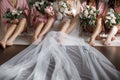 Bride with bridesmaids with flowers sitting in a row
