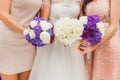 Bride with bridesmaids with flowers stand in a row