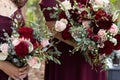 Bride with bridesmaids in magenta burgundy dresses with wedding florals - deep red and white roses with seeded eucalyptus leaves