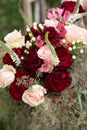 Bride with bridesmaids in magenta burgundy dresses with wedding florals - deep red and white roses with seeded eucalyptus leaves