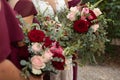 Bride with bridesmaids in magenta burgundy dresses with wedding florals - deep red and white roses with seeded eucalyptus leaves