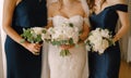 Bride with bridesmaids stand in dresses with bouquets of peonies Royalty Free Stock Photo