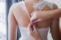 Bride buttoning wedding dress in the morning Royalty Free Stock Photo