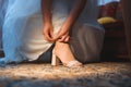 Bride clasping shoe at home