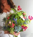 Happy bride with a colorful bridal bouquet at the wedding day