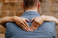 Bride creating a heart shape with her hands on the back of the groom Royalty Free Stock Photo