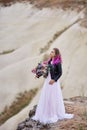 Bride with creative hair coloring looks into the distance in nature. Portrait of a woman with brightly colored hair standing in
