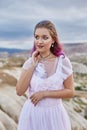 Bride with creative hair coloring looks into the distance in nature. Portrait of a woman with brightly colored hair standing in