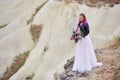 Bride with creative hair coloring looks into the distance in nature. Portrait of a woman with brightly colored hair standing in