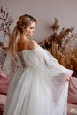 The bride dances and whirls in a white curvy dress. It& x27;s a beautiful studio. European type of appearance, blonde.