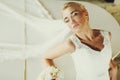 Bride daydreams standing leaned on a wite piano Royalty Free Stock Photo