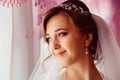 Bride with delicate face traits stands thoughtful