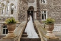 A bride in a dress climbs the stairs. Beautiful lady in a luxurious dress.