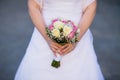 Bride in a dress standing in a green garden and holding a wedding bouquet of flowers and greenery and blur background Royalty Free Stock Photo