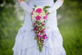 Bride in a dress standing in a green garden and holding a wedding bouquet of flowers and greenery and blur background Royalty Free Stock Photo