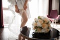 Bride dressing beautiful white stockings on feet Royalty Free Stock Photo