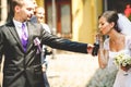 Bride drinks soda from a bottle held by groomsman