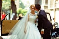 Bride enjoys groom's kiss standing in the front of an old car Royalty Free Stock Photo