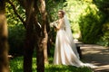 Bride in fashion wedding dress on natural background. A beautiful woman portrait in the park. Back view Royalty Free Stock Photo