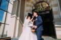 The bride is feeding the groom with the sweet while standing near the church. Royalty Free Stock Photo