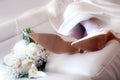 Bride feet with shoes and bouquet relaxed on the white sofa